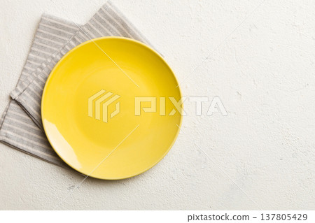 Top view on colored background empty round yellow plate on tablecloth for food. Empty dish on napkin with space for your design 137805429