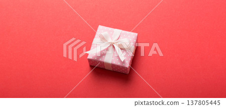 wrapped Christmas or other holiday handmade gift box in color paper with ribbon on colored background. Present box, decoration of gift on colored table, top view with copy space wrapped Christmas or other holiday handmade gift box in color paper with ribbon on colored background. Present box, decoration of gift on colored table, top view with copy space 137805445