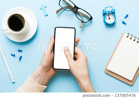 Top view of woman hands holding smart phone with blank copy space screen for your text message or information content. woman hand using phone white screen on top view Top view of woman hands holding smart phone with blank copy space screen for your text message or information content. woman hand using phone white screen on top view 137805476