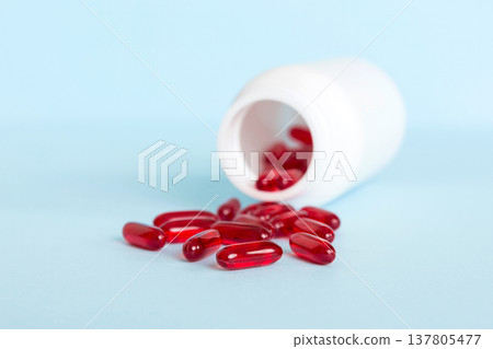 Red pills spilled around a pill bottle. Medicines and prescription pills flat lay background. Red medical capsules Red pills spilled around a pill bottle. Medicines and prescription pills flat lay background. Red medical capsules 137805477