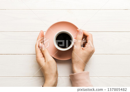 Minimalistic style woman hand holding a cup of coffee on Colored background. Flat lay, top view espresso cup. Empty place for text, copy space. Coffee addiction. Top view, flat lay 137805482