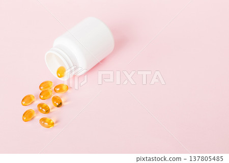 Soft gels pills with Omega-3 oil spilling out of pill bottle close-up. Gel capsules bottle white surface. Omega 3, multivitamins, Calcium, antibiotics. Health. Immunity 137805485