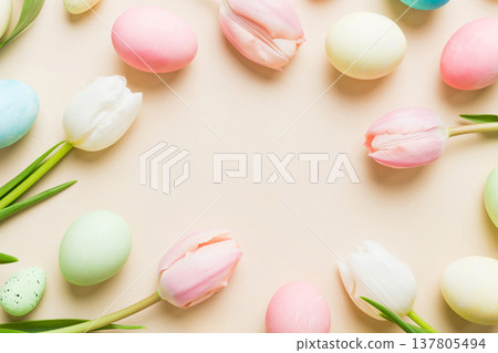 Happy Easter composition. Easter eggs on colored table with yellow Tulips. Natural dyed colorful eggs background top view with copy space Happy Easter composition. Easter eggs on colored table with yellow Tulips. Natural dyed colorful eggs background top view with copy space 137805494