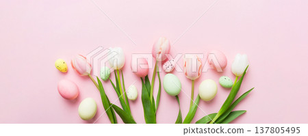 Happy Easter composition. Easter eggs on colored table with yellow Tulips. Natural dyed colorful eggs background top view with copy space Happy Easter composition. Easter eggs on colored table with yellow Tulips. Natural dyed colorful eggs background top view with copy space 137805495