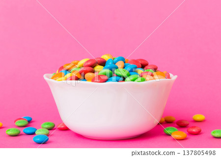 Multicolored candies in a bowl on a colored background. birthday and holiday concept. Top view with copy space Multicolored candies in a bowl on a colored background. birthday and holiday concept. Top view with copy space 137805498