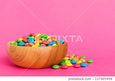 Multicolored candies in a bowl on a colored background. birthday and holiday concept. Top view with copy space Multicolored candies in a bowl on a colored background. birthday and holiday concept. Top view with copy space 137805499
