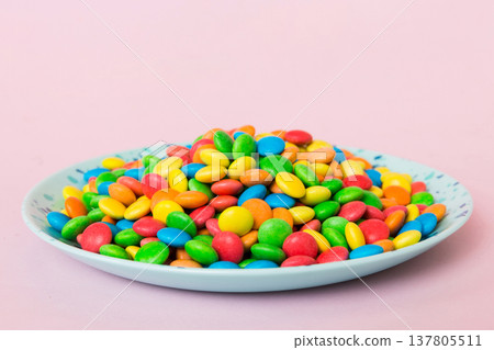 Multicolored candies in a bowl on a colored background. birthday and holiday concept. Top view with copy space 137805511