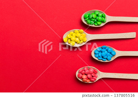 delicious colorful sweet candies on spoon on colored background . Confectionery decor top view with copy space 137805516