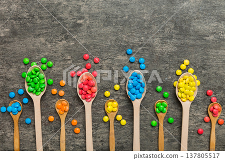 delicious colorful sweet candies on spoon on colored background . Confectionery decor top view with copy space delicious colorful sweet candies on spoon on colored background . Confectionery decor top view with copy space 137805517