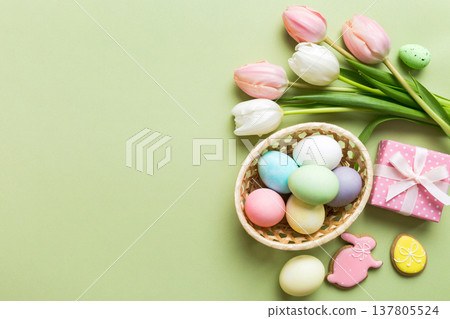 Easter frame with eggs, gift box and tulip on a colored background. The minimal concept. Top view Happy Easter composition. Card with a copy space of the place for the text Easter frame with eggs, gift box and tulip on a colored background. The minimal concept. Top view Happy Easter composition. Card with a copy space of the place for the text 137805524