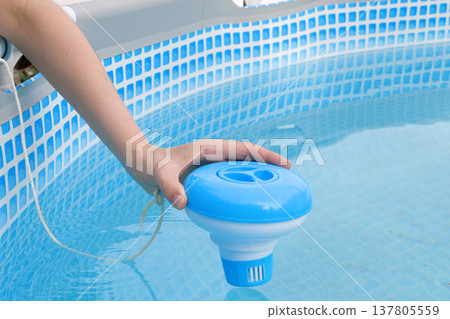Worker hands isinfection and chlorination of water in the pool. Purification from pollution pool chlor dispenser Worker hands isinfection and chlorination of water in the pool. Purification from pollution pool chlor dispenser 137805559