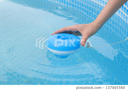 Worker hands isinfection and chlorination of water in the pool. Purification from pollution pool chlor dispenser 137805560