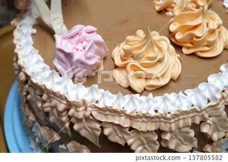 Confectioner woman is pouring cream on sponge cake using pastry bag, closeup view. Pastry chef is cooking homemade cake. cooking, baking and cooking, home cooking 137805582