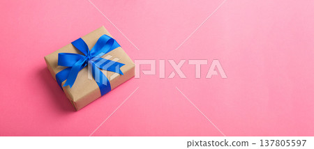 Wrapped christmas or other holiday handmade present in craft paper with colored ribbon. Present box, decoration of gift on table, top view with copy space Wrapped christmas or other holiday handmade present in craft paper with colored ribbon. Present box, decoration of gift on table, top view with copy space 137805597