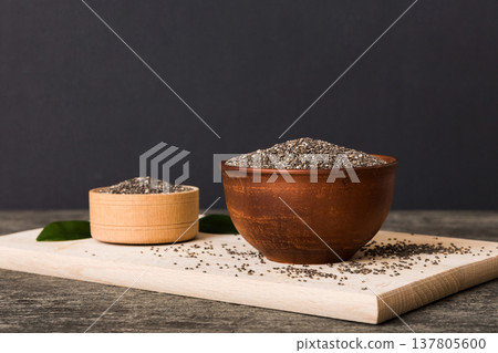 Chia seeds in bowl on colored background. Healthy Salvia hispanica in small bowl. Healthy superfood Chia seeds in bowl on colored background. Healthy Salvia hispanica in small bowl. Healthy superfood 137805600