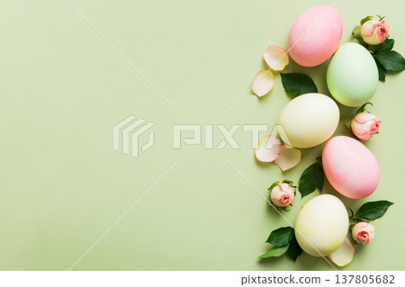 Happy Easter. Easter eggs on colored table with yellow roses. Natural dyed colorful eggs background top view with copy space 137805682