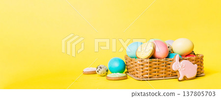 Colorful easter cookies in basket with Multi colors Easter eggs on colored background . Pastel color Easter eggs. holiday concept with copy space Colorful easter cookies in basket with Multi colors Easter eggs on colored background . Pastel color Easter eggs. holiday concept with copy space 137805703