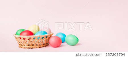 Multi colors Easter eggs in the woven basket on colored background . Pastel color Easter eggs. holiday concept with copy space Multi colors Easter eggs in the woven basket on colored background . Pastel color Easter eggs. holiday concept with copy space 137805704