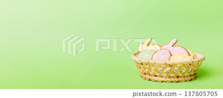 Colorful easter cookies in basket with Multi colors Easter eggs on colored background . Pastel color Easter eggs. holiday concept with copy space Colorful easter cookies in basket with Multi colors Easter eggs on colored background . Pastel color Easter eggs. holiday concept with copy space 137805705