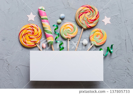 Flat lay holiday composition. Paper blank, lollipop, birthday decorations on Colored background. Top view, copy space for text Flat lay holiday composition. Paper blank, lollipop, birthday decorations on Colored background. Top view, copy space for text 137805733