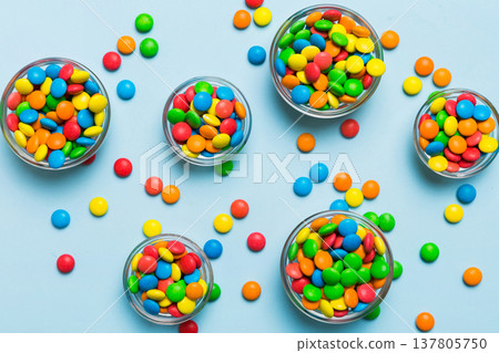 different colored round candy in bowl and jars. Top view of large variety sweets and candies with copy space different colored round candy in bowl and jars. Top view of large variety sweets and candies with copy space 137805750