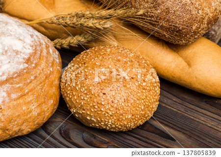 Homemade natural breads. Different kinds of fresh bread as background, perspective view with copy space Homemade natural breads. Different kinds of fresh bread as background, perspective view with copy space 137805839