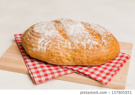 Freshly baked bread on cutting board against white wooden background. perspective view bread with copy space 137805851