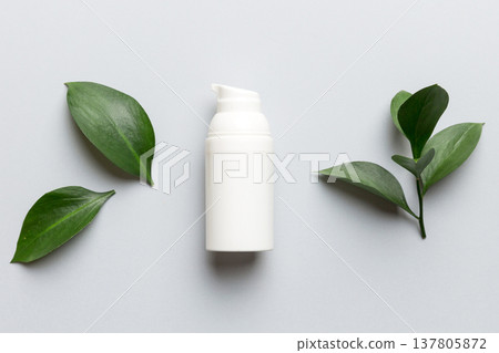 Organic cosmetic product with green leaves on color background. Flat lay 137805872