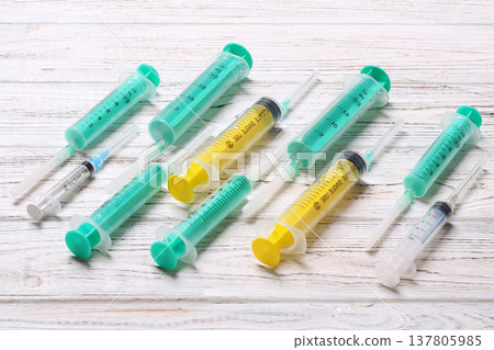 Top view of many syringes prepared for injection at wooden background. Treatment concept with copy space Top view of many syringes prepared for injection at wooden background. Treatment concept with copy space 137805985