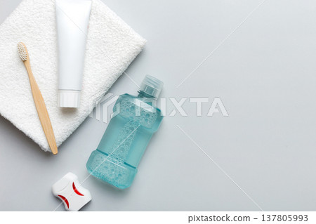 Mouthwash and other oral hygiene products on colored table top view with copy space. Flat lay. Dental hygiene. Oral care products and space for text on light background. concept Mouthwash and other oral hygiene products on colored table top view with copy space. Flat lay. Dental hygiene. Oral care products and space for text on light background. concept 137805993