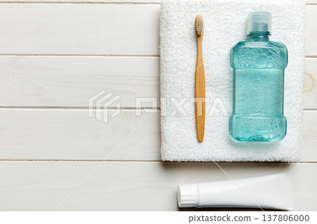 Mouthwash and other oral hygiene products on colored table top view with copy space. Flat lay. Dental hygiene. Oral care products and space for text on light background. concept Mouthwash and other oral hygiene products on colored table top view with copy space. Flat lay. Dental hygiene. Oral care products and space for text on light background. concept 137806000
