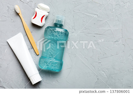 Mouthwash and other oral hygiene products on colored table top view with copy space. Flat lay. Dental hygiene. Oral care products and space for text on light background. concept Mouthwash and other oral hygiene products on colored table top view with copy space. Flat lay. Dental hygiene. Oral care products and space for text on light background. concept 137806001