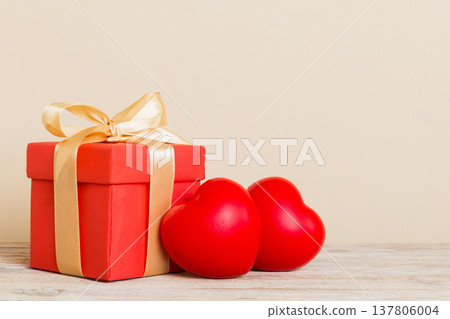 gift box with red bow and red heart on colored background. Perspective view. Flat lay gift box with red bow and red heart on colored background. Perspective view. Flat lay 137806004