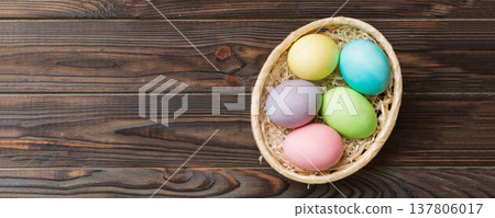 Multi colors Easter eggs in the woven basket on colored background . Pastel color Easter eggs. holiday concept with copy space 137806017