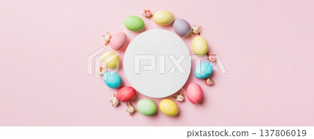 round frame multicolored Easter eggs with white blank paper on a brown background, close-up, space for text, blank for design, selective focus, tinted image 137806019