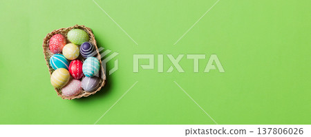 Multi colors Easter eggs in the woven basket on colored background . Pastel color Easter eggs. holiday concept with copy space Multi colors Easter eggs in the woven basket on colored background . Pastel color Easter eggs. holiday concept with copy space 137806026