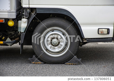The tires of a truck parked with wheel chocks installed. The tires of a truck parked with wheel chocks installed. 137806051