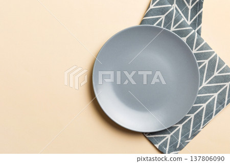 Top view on colored background empty round gray plate on tablecloth for food. Empty dish on napkin with space for your design 137806090