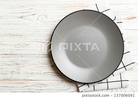 Top view on colored background empty round gray plate on tablecloth for food. Empty dish on napkin with space for your design 137806091