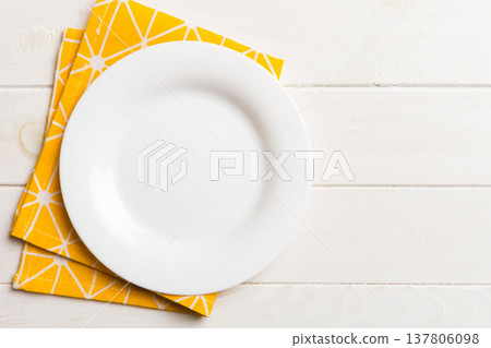 Top view on colored background empty round white plate on tablecloth for food. Empty dish on napkin with space for your design 137806098