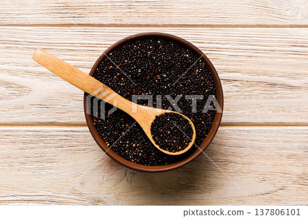 quinoa seeds in bowl and spoon on colored background. Healthy kinwa in small bowl. Healthy superfood quinoa seeds in bowl and spoon on colored background. Healthy kinwa in small bowl. Healthy superfood 137806101