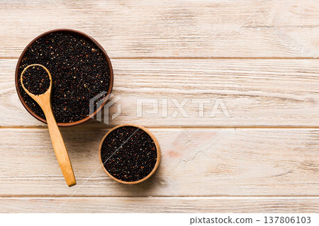 quinoa seeds in bowl and spoon on colored background. Healthy kinwa in small bowl. Healthy superfood quinoa seeds in bowl and spoon on colored background. Healthy kinwa in small bowl. Healthy superfood 137806103