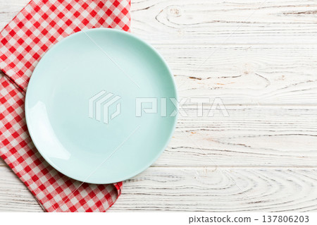Top view on colored background empty round blue plate on tablecloth for food. Empty dish on napkin with space for your design 137806203