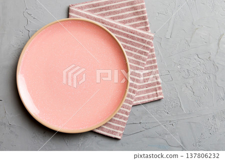 Top view on colored background empty round pink plate on tablecloth for food. Empty dish on napkin with space for your design Top view on colored background empty round pink plate on tablecloth for food. Empty dish on napkin with space for your design 137806232