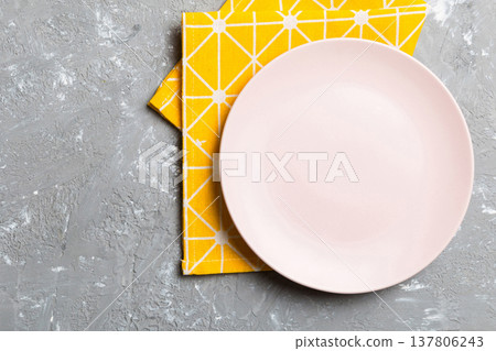 Top view on colored background empty round pink plate on tablecloth for food. Empty dish on napkin with space for your design Top view on colored background empty round pink plate on tablecloth for food. Empty dish on napkin with space for your design 137806243