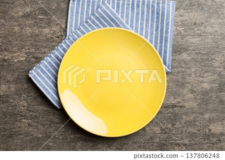 Top view on colored background empty round yellow plate on tablecloth for food. Empty dish on napkin with space for your design 137806248