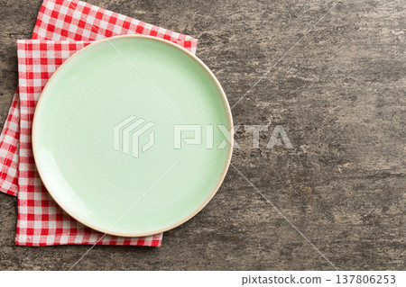 Top view on colored background empty round green plate on tablecloth for food. Empty dish on napkin with space for your design 137806253