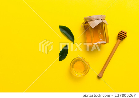 Honey jar with wooden honey dipper on white background top view with copy space. Delicious honey bottle 137806267