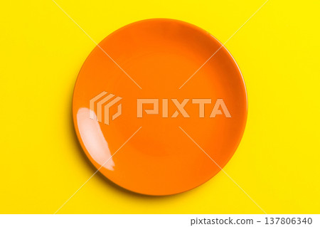 Top view of isolated of colored background empty round orange plate for food. Empty dish with space for your design 137806340