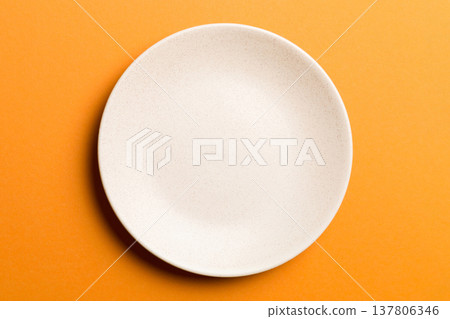 Top view of isolated of colored background empty round beige plate for food. Empty dish with space for your design 137806346